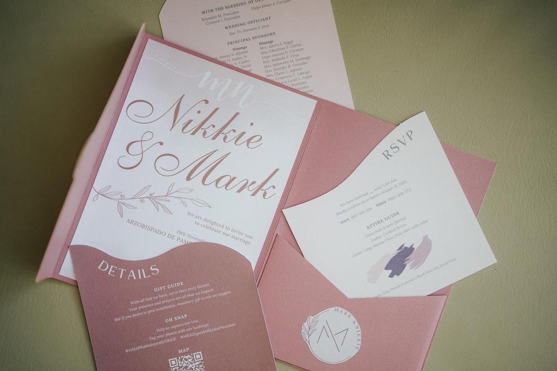 A dusty rose invitation suite laid out in pieces — the invitation, an RSVP card and a details card.